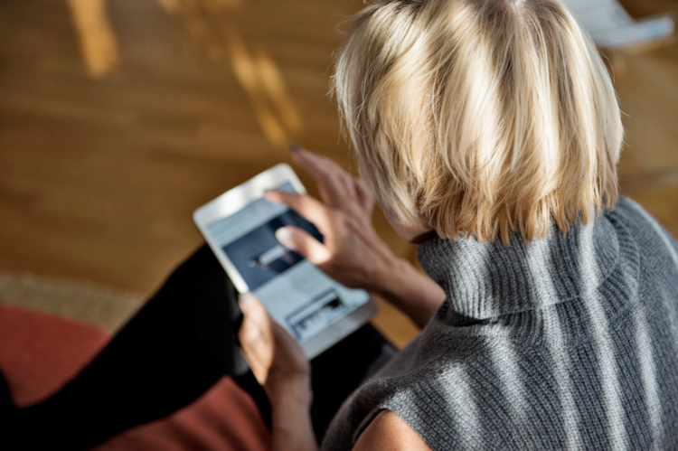  A woman reading news on a tablet.