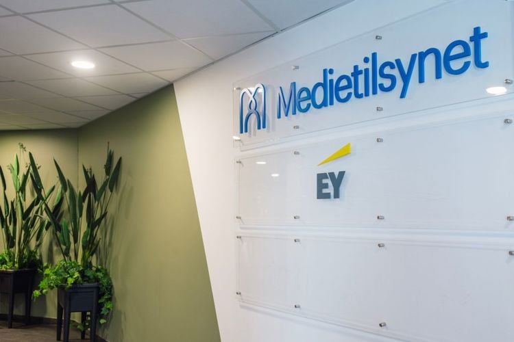 Bilete frå inngangspartiet til Medietilsynets kontor. Medietilsynets logo i blått mot kvit bakgrunn på veggen. Ein grøn plante i hjørnet.