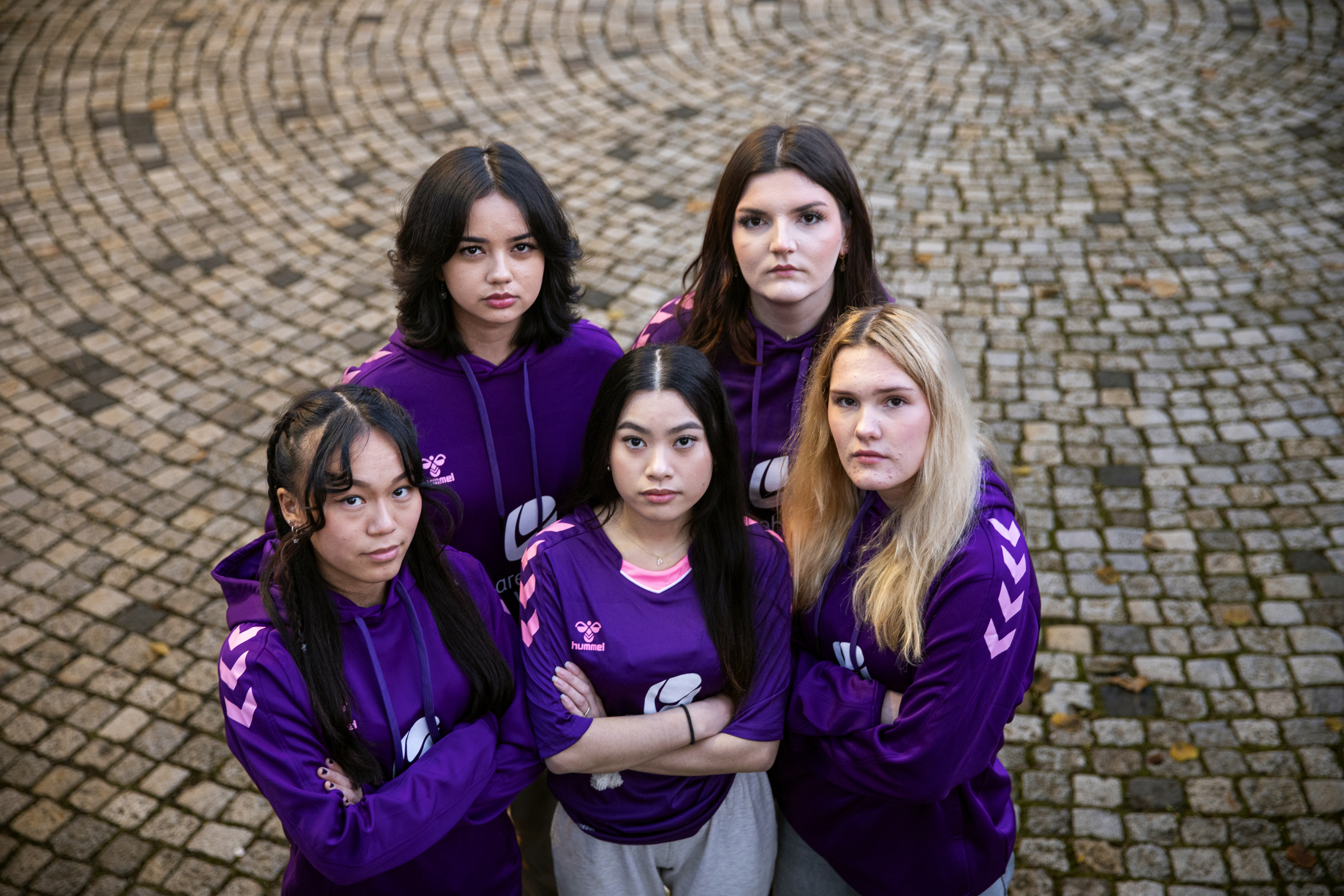 Fem jenter står sammen ikledd drakten til deres e-sportlag