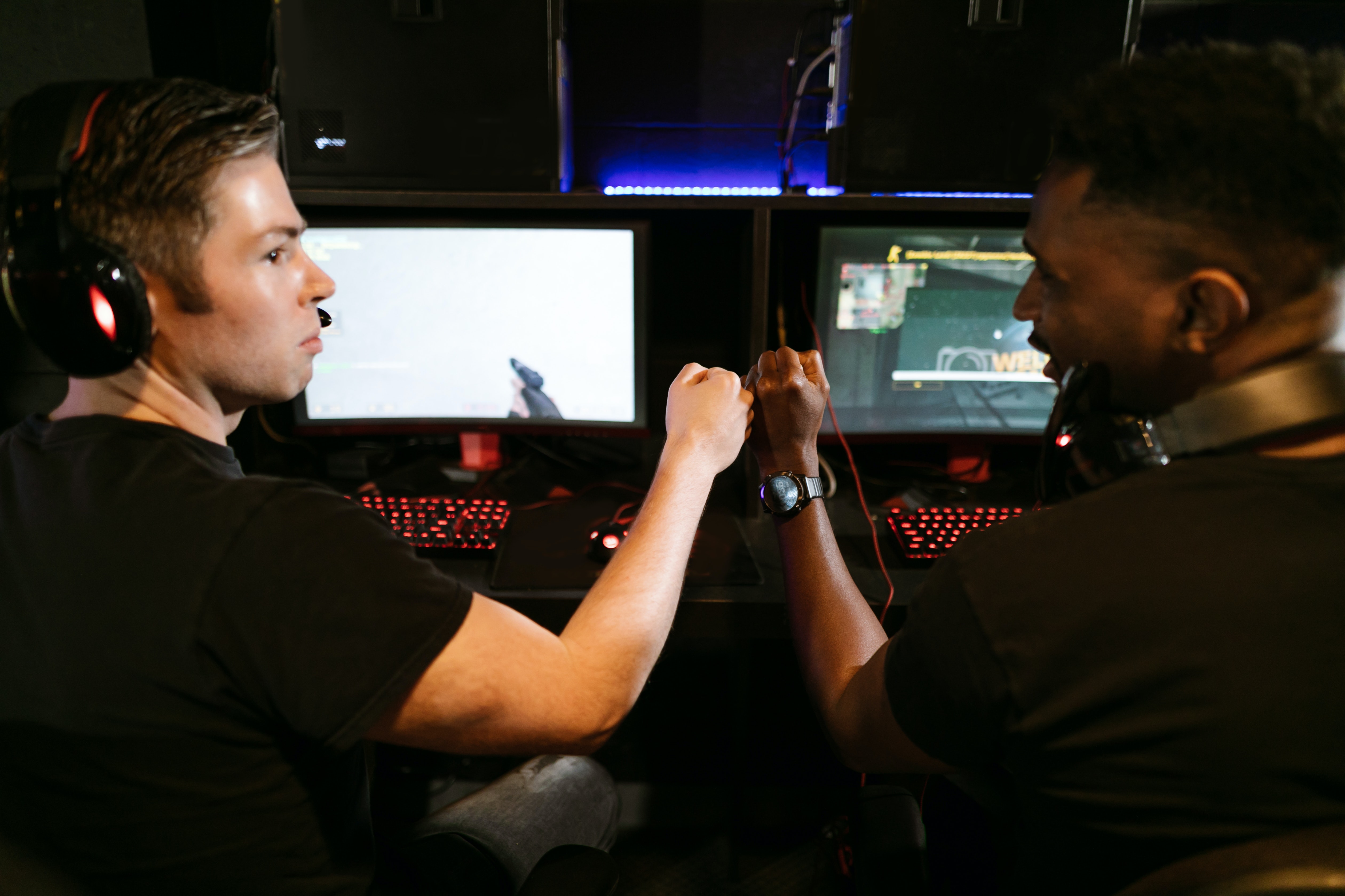 To gutter som spiller dataspill gir hverandre en fistbump mens de gjør seg klar til å konkurrere.